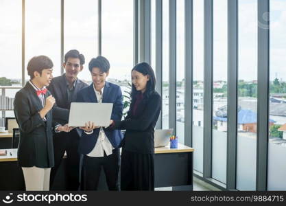 Successful happy workers Group of asian business people with diverse genders  LGBT  see a successful business plan on the laptop computer in the meeting room at office