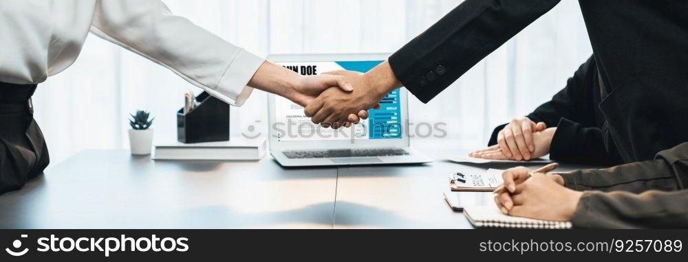 Successful job interview at business office end with handshake. Hired candidate seal deal with HR team recruiter by handshaking with laptop display digital resume in background. Panorama shot. Prodigy. Successful job interview at business office end with handshake. Prodigy