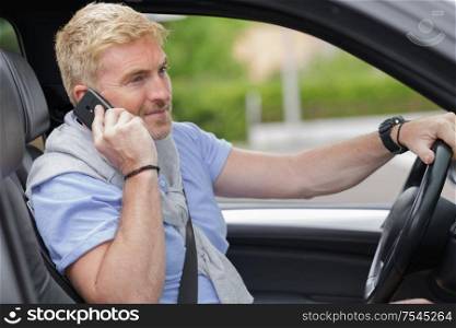 successful man working on phone while driving