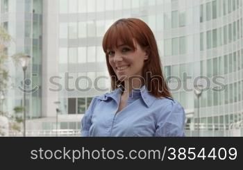 Successful people at work, confident business woman with red hair smiling at camera near office building. Sequence