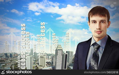 Successful young businessman standing against modern cityscape