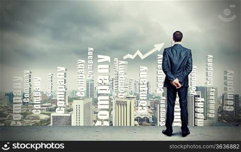 Successful young businessman standing against modern cityscape