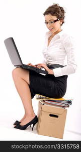 Successful young businesswoman sitting on pile of documents, lots of copy space