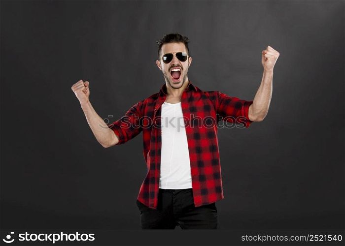 Successful young latin man with arms up