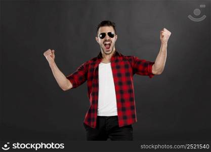 Successful young latin man with arms up