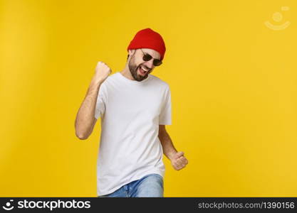 Successful young man celebrating against a yellow background. Successful young man celebrating against a yellow background.