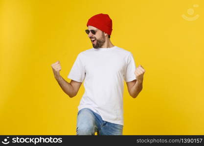 Successful young man celebrating against a yellow background. Successful young man celebrating against a yellow background.