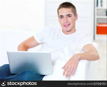 successful young man with laptop at home