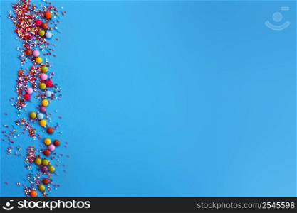 Sugar baking colorful sprinkles in shape of circle isolated on a blue background. Holiday concept. copy space. Sugar baking colorful sprinkles in shape of circle isolated on blue background. Holiday concept copy space