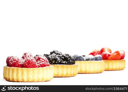 sugar covered raspberries in tartlet in front of wild berries. sugar covered raspberries in a tartlet in front of wild berries on white background