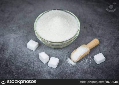 Sugar cubes and white sugar on bowl with gray background , top view