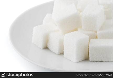 Sugar cubes in saucer on white background