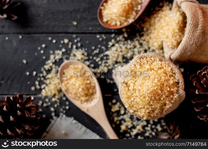 Sugar in a cup and spoon on a black table.