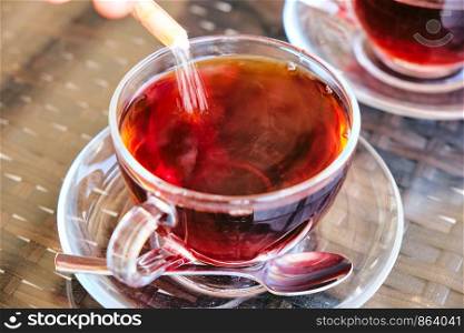 sugar poured in traditional turkish tea in glass. traditional turkish tea