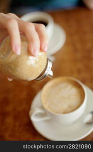 Sugar pouring into a cup of tea