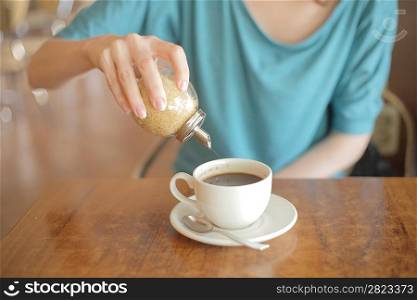 Sugar pouring into a cup of tea
