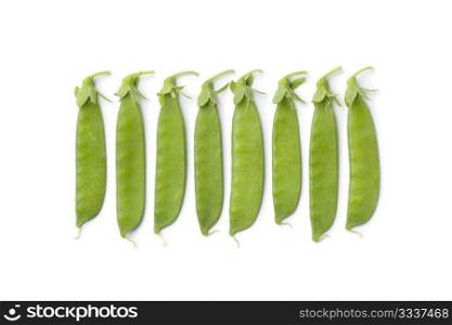 Sugar snap peas in a row on white background