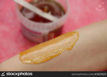 Sugaring: epilation with liquate sugar at legs. It is less painful hair removal with wax replacement