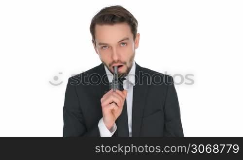 Suicidal businessman holding a gun to his mouth driven to taking his own life by failure, stress, depression or a crisis at the office, isolated on white