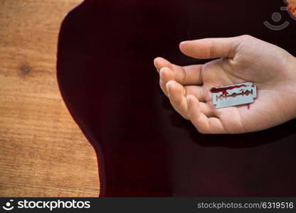 suicide, death and people concept - close up of dead woman hand in blood on floor at crime scene. dead woman hand in blood on floor at crime scene