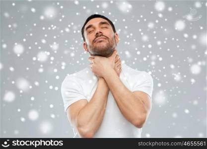 suicide, death, winter, christmas and people concept - young man choking himself by hands over snow on gray background