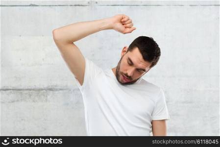 suicide, despair, death and people concept - young man making gallows or hanged gesture over gray wall background