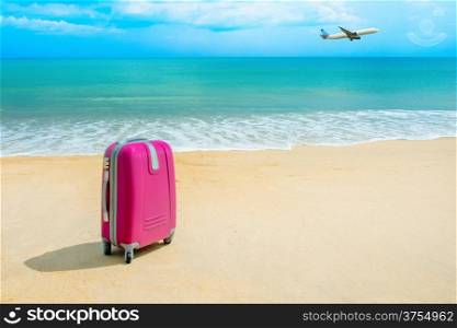 Suitcase at the sunny beach near the sea