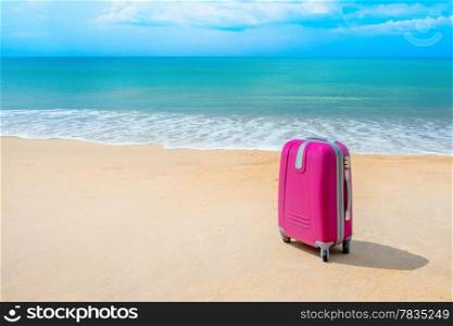 Suitcase at the sunny beach near the sea