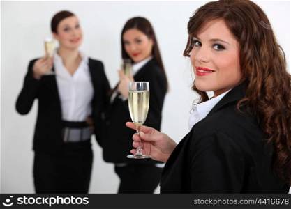 Suited women drinking champagne