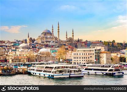 Suleymaniye Camii, the famous mosque on Golden Horn and touristic boats in Istanbul at sunset, Turkey. Suleymaniye Camii at sunset