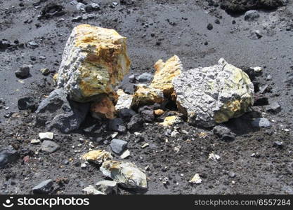 Sulphur rocks on the dark sand of volcano Krakatau in Indonesia