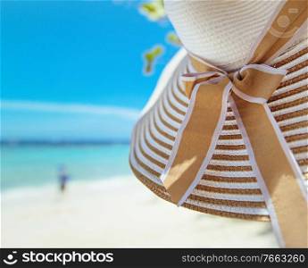Summer accessories - straw hat, white beach, exotic view