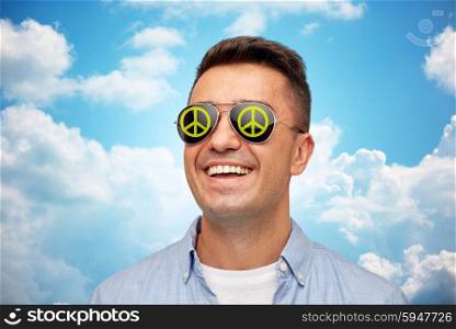 summer, accessories, style and people concept - face of smiling middle aged man in sunglasses with green peace symbol over blue sky and clouds background