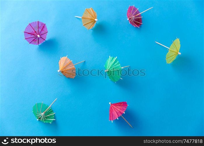 summer, accessory and decoration concept - cocktail umbrellas on blue background. cocktail umbrellas on blue background