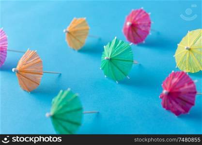 summer, accessory and decoration concept - cocktail umbrellas on blue background. cocktail umbrellas on blue background