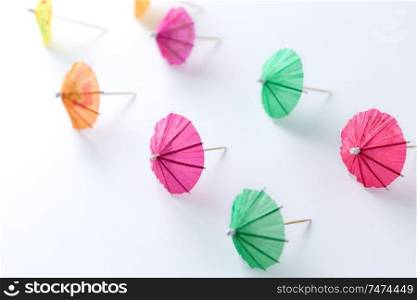 summer, accessory and decoration concept - cocktail umbrellas on white background. cocktail umbrellas on white background