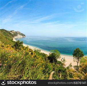 Summer Adriatic sea bay and blossoming Spiaggia Mezzavalle beach near Portonovo and Ancona towns in the Marche region. Italy, Conero Riviera. People unrecognizable.