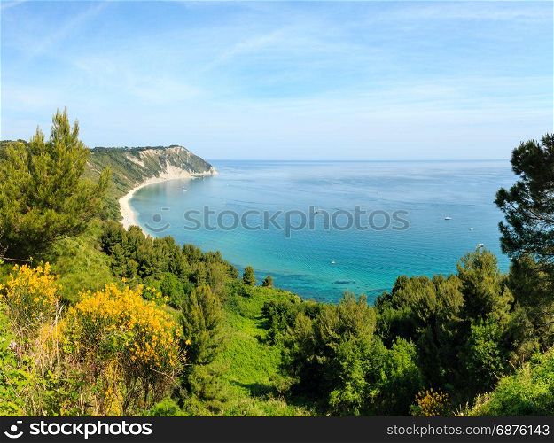Summer Adriatic sea bay and blossoming Spiaggia Mezzavalle beach near Portonovo and Ancona towns in the Marche region. Italy, Conero Riviera. People unrecognizable.