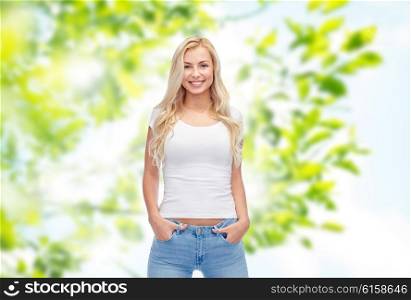 summer, advertisement and people concept - happy smiling young woman or teenage girl in white t-shirt over green natural background