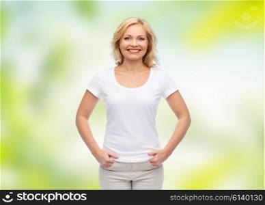 summer, advertisement and people concept - smiling woman in blank white t-shirt over green natural background