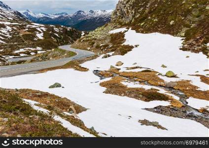 Summer Alps mountain landscape with alpine road and small stream (Fluela Pass, Switzerland)