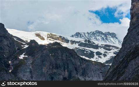 Summer Alps mountain landscape with snow covered rocky tops in far, Switzerland.