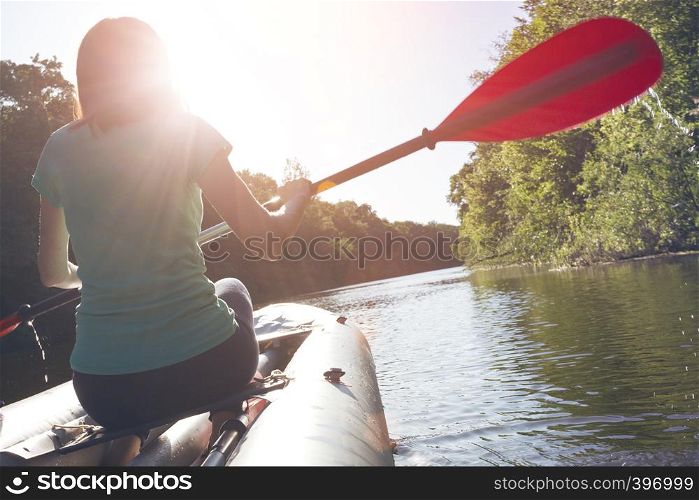 summer and active sport. a girl kayaking in sunset time