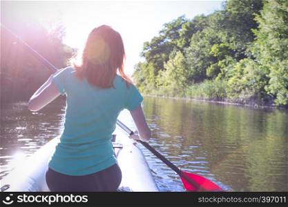 summer and active sport. a girl kayaking in sunset time