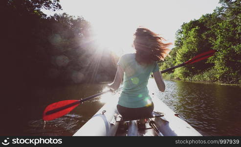 summer and active sport. a girl kayaking in sunset time