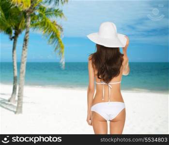 summer and holidays concept - woman posing in white bikini with hat