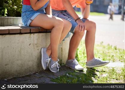 summer and people concept - happy teenage couple sitting on city street bench. happy teenage couple sitting on city street bench