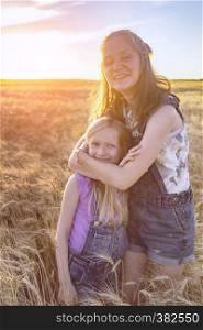 summer and vacation, Smiling happy girls sisters on the wheat field