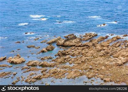 Summer Atlantic ocean (Biscay bay) coast with rock formations near shore .