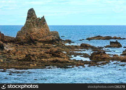 Summer Atlantic ocean (Biscay bay) coast with rock formations near shore .